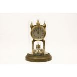 An early 20th century Becker brass anniversary clock, under a glass dome 30cm high