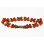 A three row coral bead and cultured pearl bracelet, with gold clasp marked 9ct11.84g