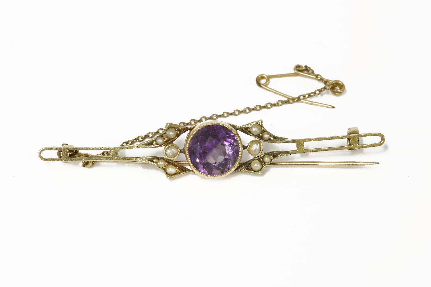 An Edwardian gold single stone round cut amethyst bar brooch, flanked with seed pearls4.37g