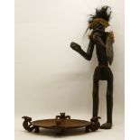 A carved hardwood African figure, with a hair wig and applied shield, 71cm high, and a carved