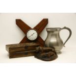 A large pewter measure, 27cm high, together with a 1950s teak wall clock, an Indian carving of a