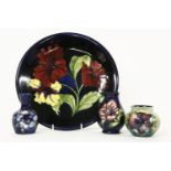 Four Moorcroft items, comprising: a plate, 26cm diam. and three small vases. Tallest 10cm (4)