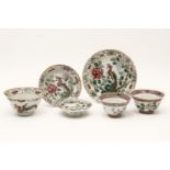 Chinese famille rose cups and saucers, of lobed circular form, painted with a phoenix and peony,