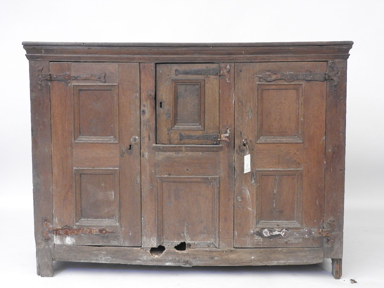 A 17th century Dutch panelled door cupboard, (rodent holes), 168cm long x 125cm high