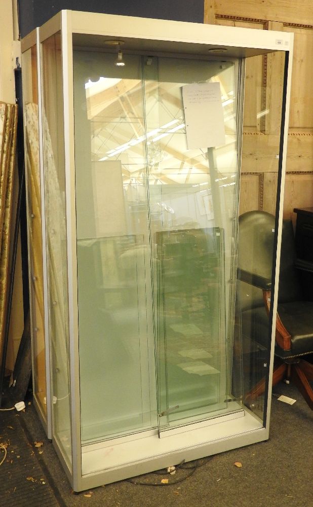 A contemporary shop display cabinet, fitted pair of sliding glass doors enclosing shelves,100 cm