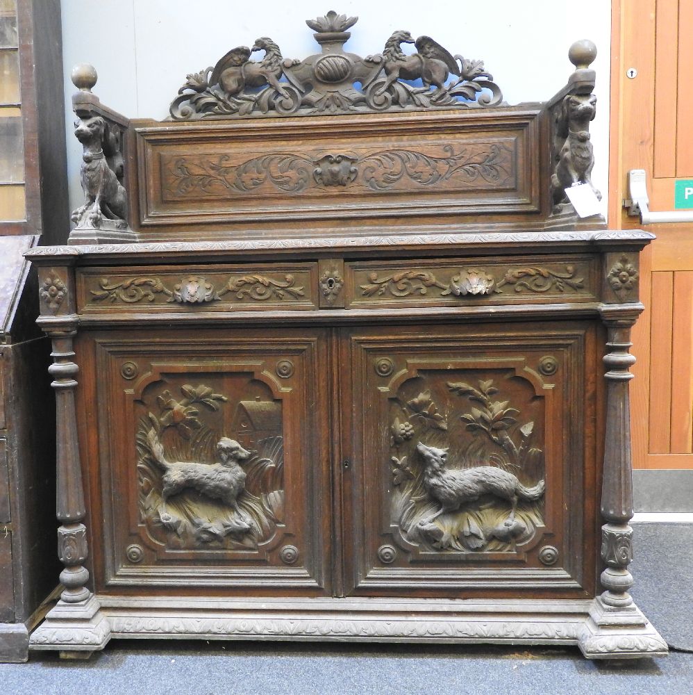 A Victorian oak sideboard, carved with griffins, dogs and flowers, 144cm wide (reduced)