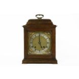 An early 20th oak cased table clock, striking on a gong