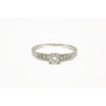 A single stone diamond ring with six brilliant cut diamonds to shoulders, marked 10% irid.