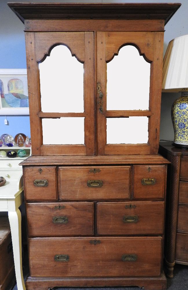 A large colonial hardwood cupboard, the upper section with mirrored doors over, the base