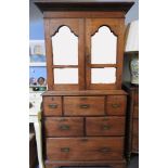 A large colonial hardwood cupboard, the upper section with mirrored doors over, the base