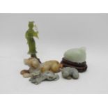 A collection of Chinese hard stone carvings, comprising a deity, a quail, a recumbent dog, a