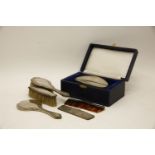 A child's silver backed hand mirror, together with matching brushes and comb, together with a