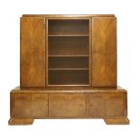 An Art Deco display cabinet, the central sliding glass doors enclosing three shelves, flanked with