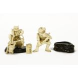 A Japanese ivory figure of a Samurai drawing his sword, signed, damaged, 6.5cm high, and a figure of