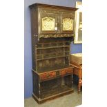 An unusual French dresser, with a cupboard, with brass panels, over two plate racks, two further