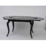 An Anglo-Indian dining table, possibly padouk with one extra leaf, the frilled edge with an inner