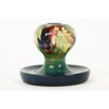 A Moorcroft candlestick, berries and leaves pattern, with dished base. 11cm high.