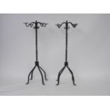 A pair of wrought iron floor standing garden picket four branch candelabra, the scroll branches on