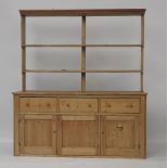A pine dresser with three drawers over three cupboards, the open plate rack with two shelves,