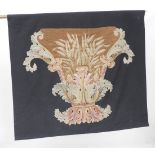 An Abusson design needlework wall hanging of a classical urn mounted on a black ground, together