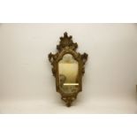 A 19th Century giltwood wall mirror, the carved frame detailing a leaf surmount