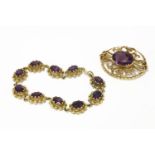 A 9ct gold single stone oval cut amethyst brooch, double claw set to a scrolling pierced back, and a