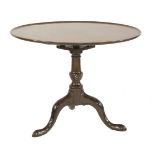 A George III mahogany tripod table, the circular dished top over a birdcage, with a turned column on