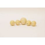 Five 19th century turned ivory balls, four 3.5cm diameter, the other 5cm