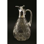 An early 20th century Art Nouveau cut glass and silver mounted claret jug, the ovoid body with cut