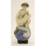 A Royal Doulton figure 'The Bather',by John Broad, modelled as a nude seated on a ball watching a