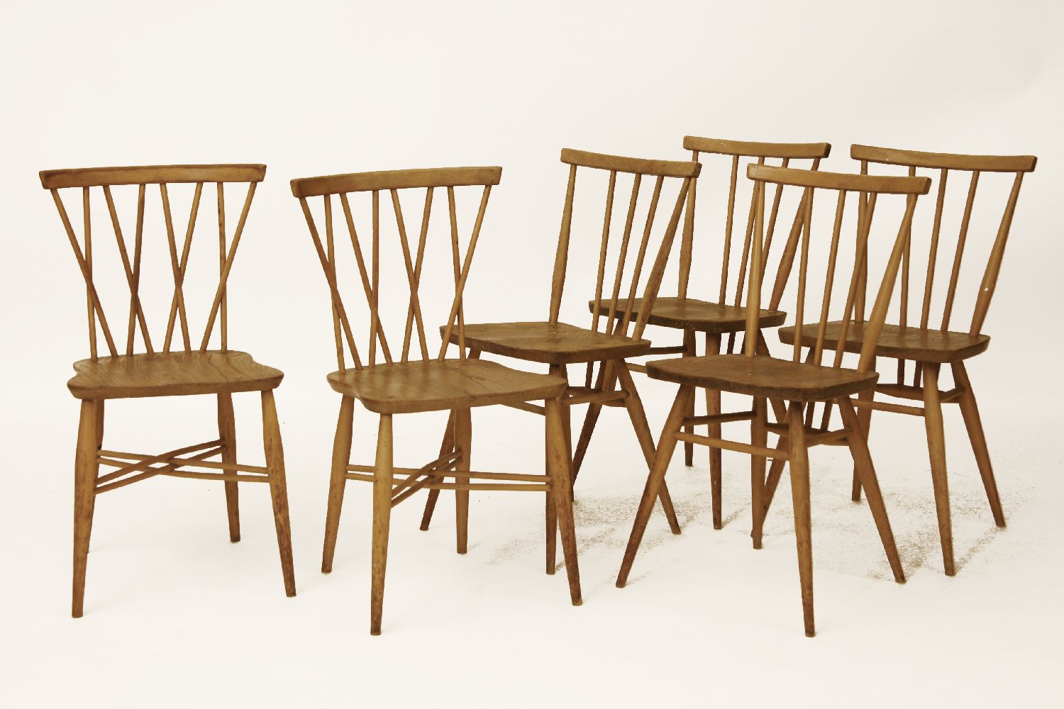 A set of four Ercol light elm dining chairs, with spindle backs, together with a pair of similar