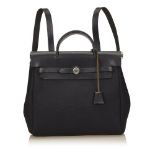 An Hermès 'Herbag MM' backpack, with a black canvas body, a front flap, flat leather straps and a