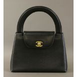 A Chanel black caviar lambskin leather 'Kelly' style handbag, with two hard handles and double 'C'