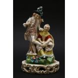 A Derby figure of ‘the stocking mender’,c.1820, the man stands while the female mends his