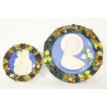 Two 20th century Della Robbia style pottery plaques, the largest 29cm diameter