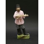 A Russian biscuit porcelain figure, the Balalaika player, on naturalistically formed base, stamped