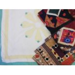 A white ground quilt with green and yellow border and flower design, and two pieces of quilted