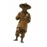 A Chinese wood carving, 20th century, of a fisherman, wearing a large hat, standing with a smile,