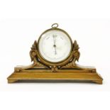 A Negretti & Zambra aneroid barometer, in lacquered brass case and on a carved oak stand, 32cm