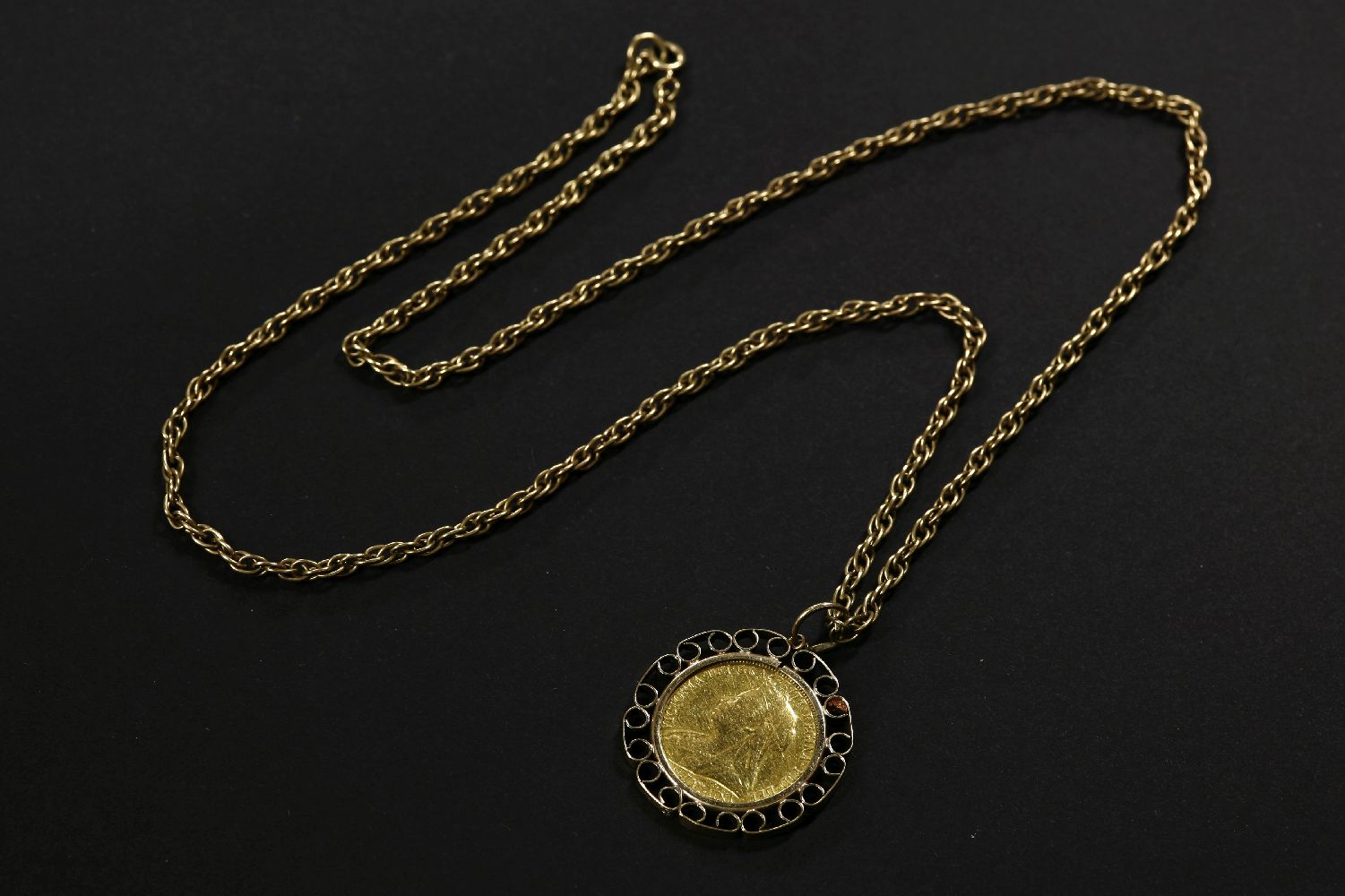 A 1900 gold sovereign, channel set in a 9ct gold mount on a 9ct gold Prince of Wales chain23.30g