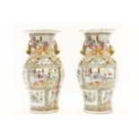 A pair of late 19th century Canton famille rose vases, with gilt highlights and painted with