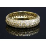 A gold pavé diamond set 'D' section band ring,5.2mm wide, pavé set with with three rows of graduated