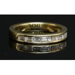 An 18ct gold diamond half eternity ring,with a row of baguette cut diamonds, channel set to a flat