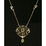 An Art Nouveau gold peridot pendant,by Murrle Bennett & Co. A whiplash form pendant with an oval