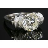 An odeonesque single stone diamond ring, c.1935-1940,with diamond set shoulders, . A brilliant cut