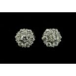 A pair of white gold, seven stone diamond cluster earrings, with a brilliant cut diamond, claw set