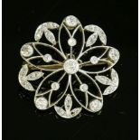 A Belle Époque, diamond set brooch/pendant,of pierced flower form. An old European cut diamond,