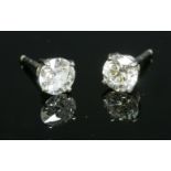 A pair of 18ct white gold single stone diamond earrings,with one old brilliant cut diamond and one