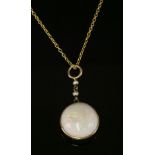 An Edwardian single stone opal pendant,with a circular tallow cut cabochon opal, spectacle set to