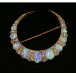 A Victorian gold, opal and diamond closed crescent brooch,with a row of graduated oval, cabochon